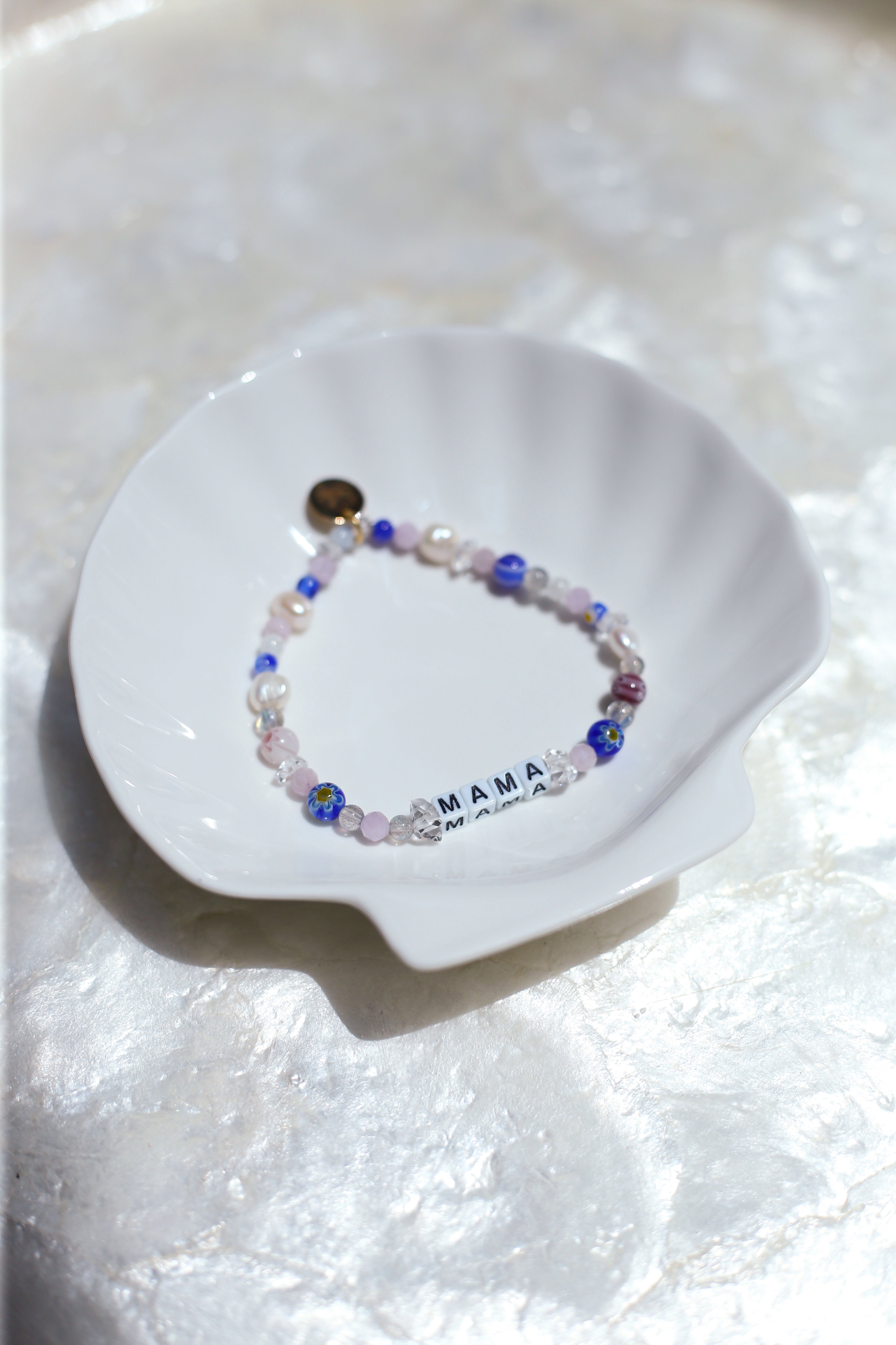 Florence customizable gemstone bracelet with pearls and letter beads on a white dish