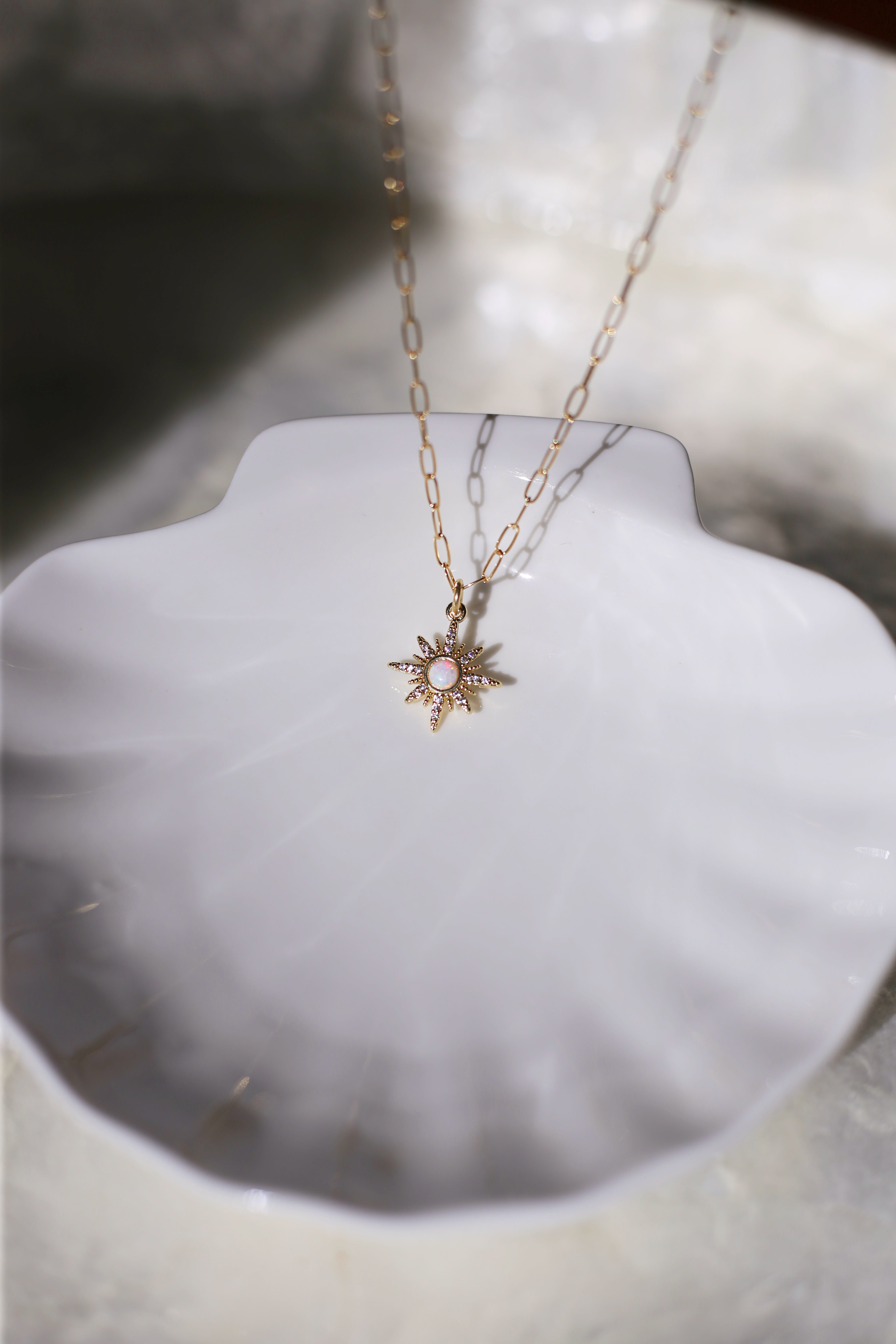 Gilly Gold with Opal Center Starburst Charm On Shell Plate Bokeh