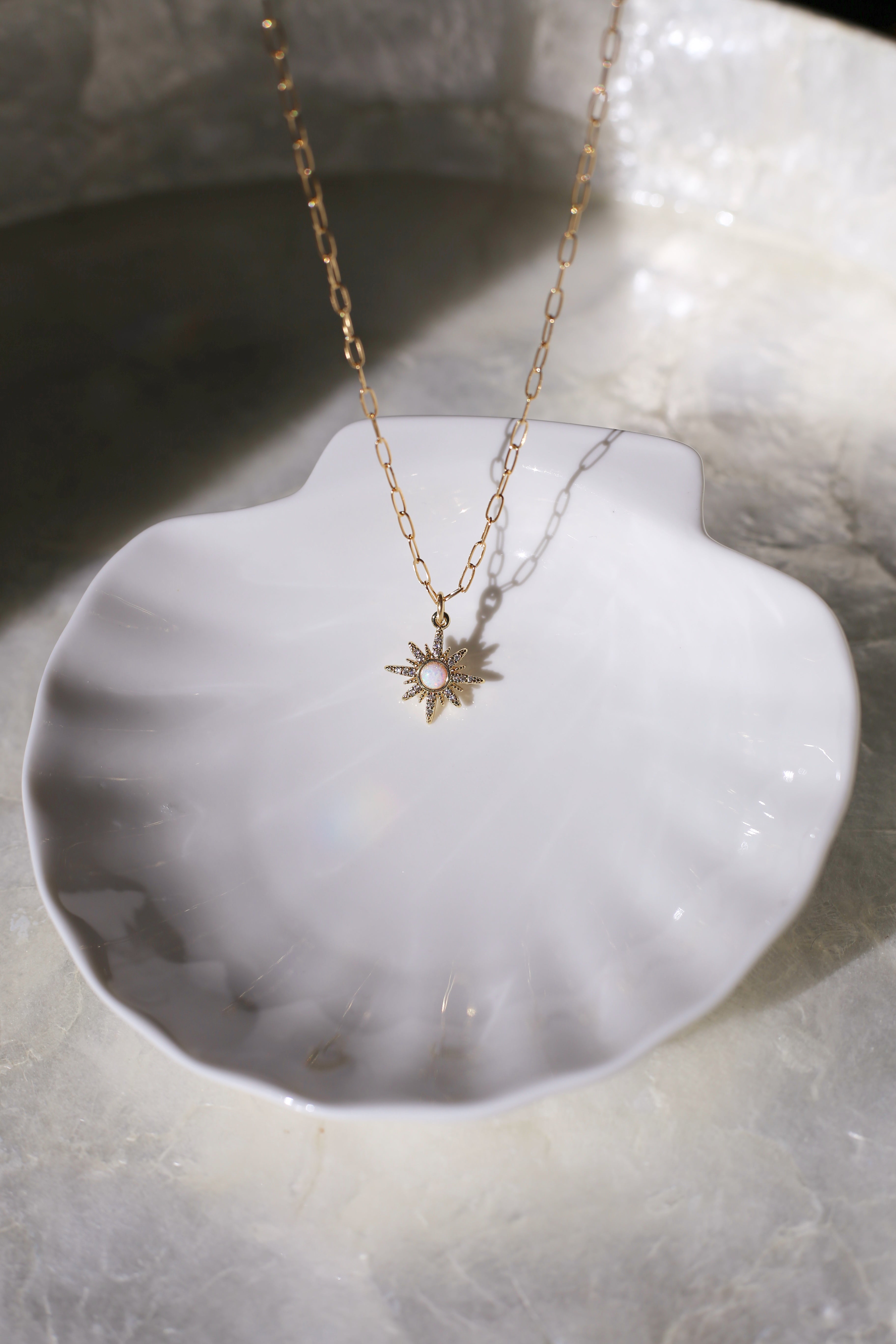 Gilly Gold with Opal Center Starburst Charm On Shell Plate Focused