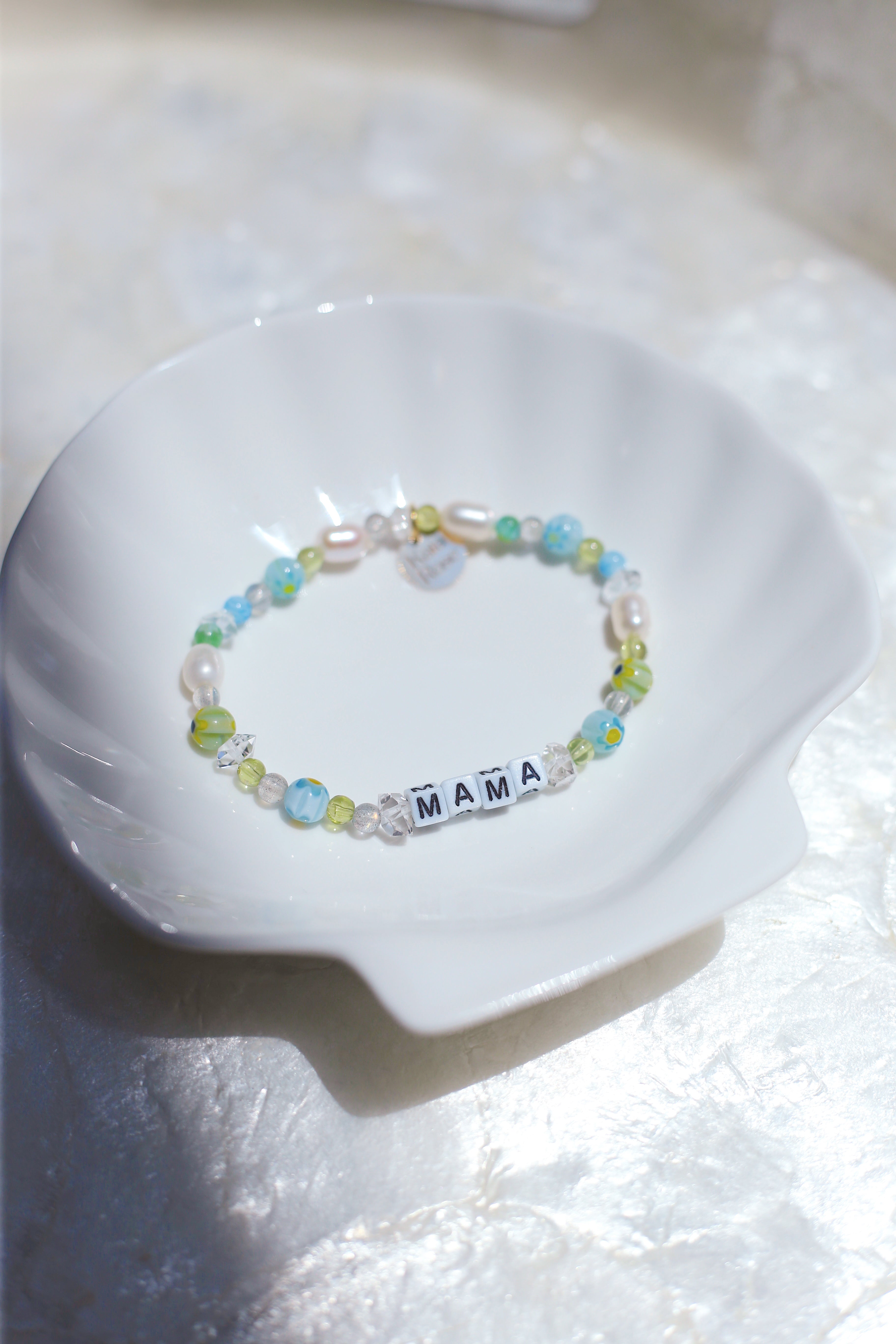 Meraki gemstone bracelet with pearls on a white ceramic dish