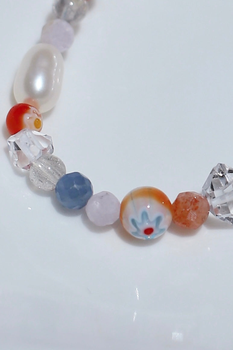 Close-up of Tangerine bracelet beads - orange, blue gemstones and letter charm